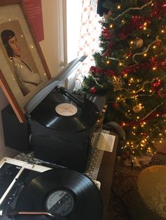 an old record player sitting next to a christmas tree with a elvis presley portrait on it