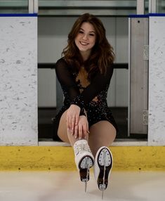 a woman sitting on the ice with her legs crossed