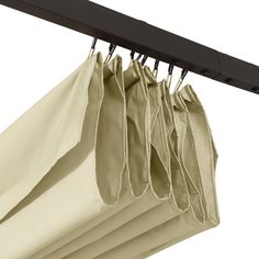 several bags are hanging from a rail with black clips on the bottom and one bag is beige