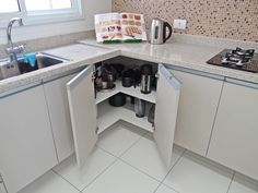 an open cabinet in the corner of a kitchen