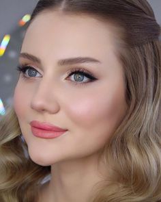 a woman with blonde hair and blue eyes is posing for a photo in front of the camera