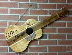 a wooden guitar hanging on a brick wall