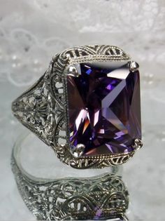 Inspired by Victorian era designs, this lovely filigree reproduction has been recreated in sterling silver. This flawless 5 carat gemstone is 12mm x10mm in size. Please choose from a VS to VVS natural purple amethyst or a flawless purple cubic zirconia gemstone. The inside of the band is etched 925 for sterling silver. Victorian Rings, Womens Jewelry, Detailed Design, Pretty Rings, Vintage Lover