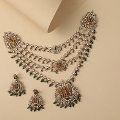 Description : Experience luxury with the Janaki four-layer grand silver necklace, featuring vintage Victorian plating, moissanite stones, emerald green gemstones, and semi-precious beads. The central Ramparival motif is skillfully crafted by our skilled artisans, showcasing their care and precision, making it a perfect addition to your bridal trousseau. Product Information : Materials used: 925 Silver with 1.0-microns Victorian Plating Stones: Semi-precious stones & semi-precious beads Length: F Luxury Temple Jewelry With Gemstone Beads, Bridal Trousseau, Saree Jewellery, Precious Beads, Semi Precious Beads, Vintage Victorian, 925 Silver Jewelry, Semi Precious Stones, Green Gemstones