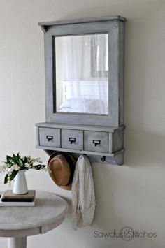 a bathroom with a mirror, sink and jewelry rack on the wall next to it