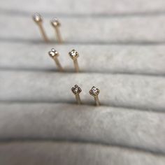 These tiny micro diamond gold studs are sold both individually and in pairs, this is to allow you to build up whatever ear stack you are aiming for.  The tiny, 1.2mm natural genuine diamond stud is classic yet modern and they would seamlessly fit into an existing ear stack or add some very subtle sparkle alone.  They are made in solid recycled 9ct yellow gold and the fastening is a post and little butterfly.  The photos at the end show them being worn in the top hole on the lobe in a curated ear look to demonstrate just how tiny they are.  If you require more of this item than is showing as available to purchase please send me a message and I can advise on if I have more available.  All of my items are handmade by myself in my workshop in Surrey, England.  They come well packaged in a bran 14k Gold Diamond Earrings With Diamond Eyes For Anniversary, Minimalist Yellow Gold Earrings With Diamond Eyes, Diamond Nose Studs In Yellow Gold For Gift, Diamond Yellow Gold Nose Studs For Gift, Minimalist Diamond Eyes Earrings For Anniversary, Dainty Diamond Earrings With Single Cut Diamonds, Delicate Gold Earrings With Single Diamond, Gold Single Diamond Delicate Earrings, Gold Delicate Diamond Earrings With Single Stone