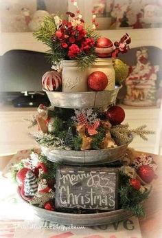 three tiered christmas tree with ornaments on top and chalkboard sign in the middle