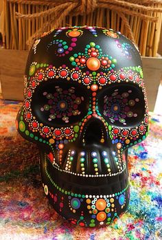 a painted skull sitting on top of a colorful rug