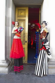 two women dressed in costumes standing outside an entrance