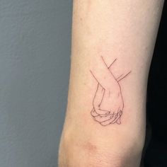 a couple of hands holding each other on the wrist tattoo designs for men and women