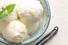 three scoops of ice cream in a blue bowl with a mint sprig