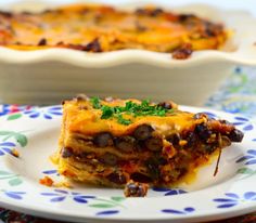 a piece of lasagna sitting on top of a plate next to a casserole dish