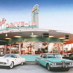 several classic cars parked in front of a drive - in