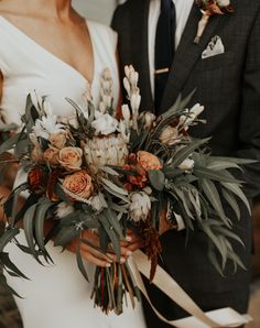 a bride and groom are holding their bouquets