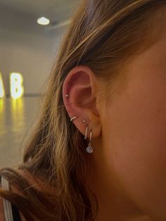 a close up of a person with ear piercings on their ears and wearing earrings