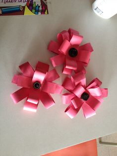 four pink flowers are sitting on the table