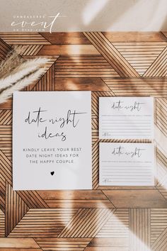 the wedding stationery is laid out on top of a wooden table with white writing