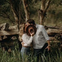 a man and woman kissing in the woods