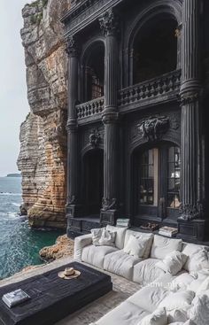 a large white couch sitting in front of a building near the ocean