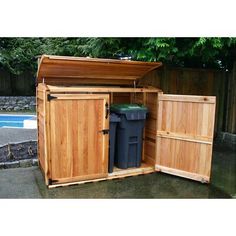 an outdoor storage shed with the doors open and two trash cans in front of it