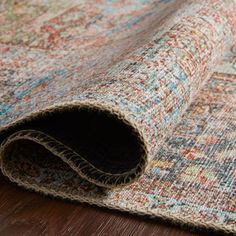 an area rug is laying on top of a wooden floor with the end rolled up