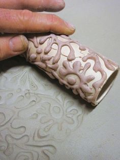 a person holding a piece of clay in their left hand and the other hand on top of it