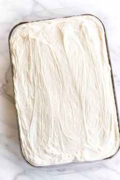 a pan filled with white frosting sitting on top of a counter