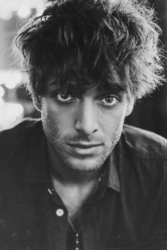 a black and white photo of a man with curly hair