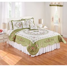 a bed with green and white bedspread in a bedroom next to a window