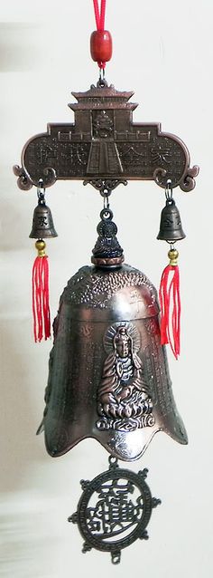 a metal bell with red tassels hanging from it