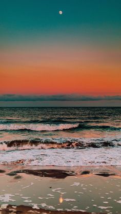 the sun is setting over the ocean with waves crashing in front of it and an orange glow on the horizon