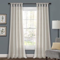 a living room scene with focus on the curtain and chair in front of the window