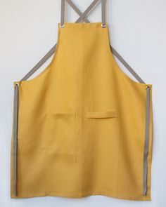 a yellow apron hanging on the wall