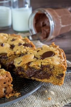 chocolate chip cookie bars on a plate with milk in the background