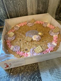 a cake in a box with pink and white frosting on it's side