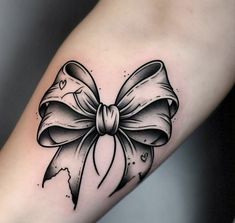 a black and white bow tattoo on the arm