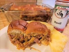 a sandwich cut in half sitting on top of a white plate next to a container of macaroni and cheese