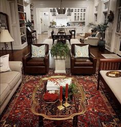 a living room with couches, chairs and a coffee table in front of a fireplace