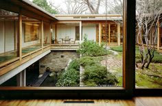 the inside of a house with wooden flooring and large windows looking out onto trees