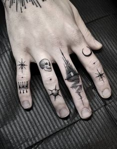 a person's hand with tattoos on it and a star, moon, and castle