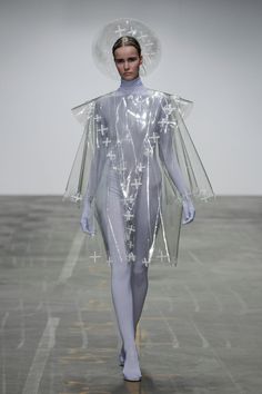 a model walks down the runway wearing plastic clothing