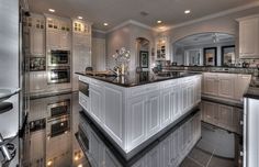 a large kitchen with stainless steel appliances and marble counter tops