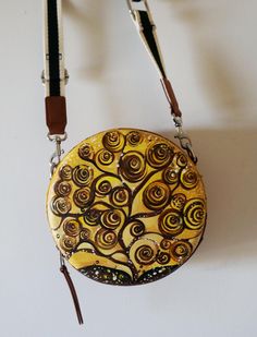 a purse with a tree on it hanging from a hook