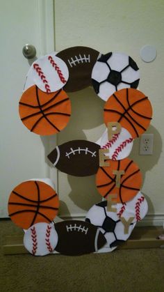 a wreath made to look like a basketball, football ball and cross on the front door