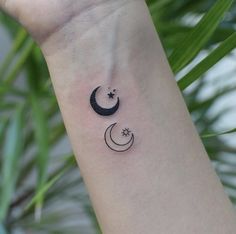 a woman's wrist tattoo with two crescents and stars on the left side