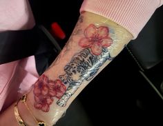 a woman's arm with flowers on it and a tiger in the middle of her arm