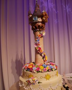 there is a large cake decorated with flowers on the top and a tower in the middle