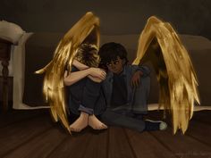 two people sitting on the floor with their arms around each other and wings spread out