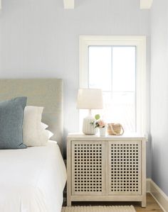 a white bed sitting next to a window in a bedroom