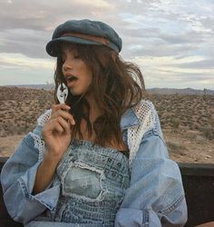 a woman sitting in the back of a pick up truck holding a cell phone to her ear